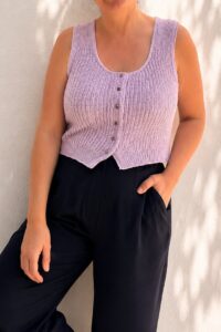 Top Moema de punto en lila claro con botones, vista frontal sobre pantalón negro